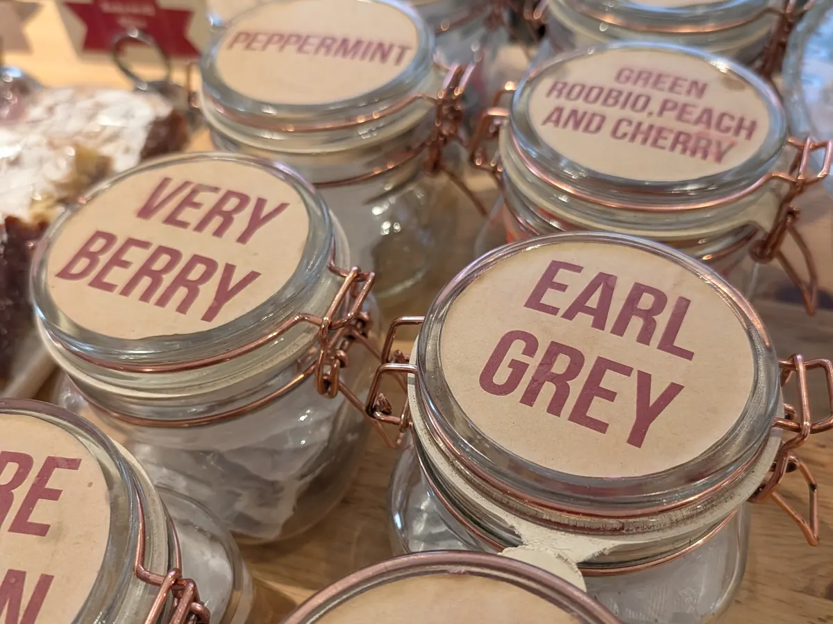 Jars of loose leaf tea on the café counter, including Earl Grey, Very Berry and Peppermint